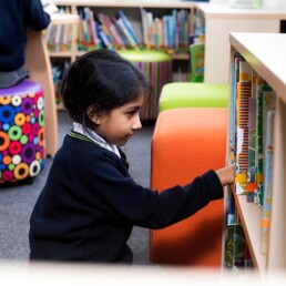 Girl choosing a book from bookcase